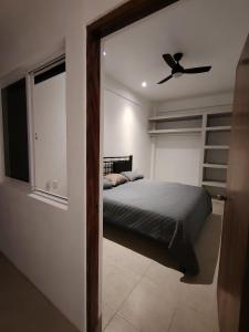 a bedroom with a bed and a ceiling fan at Depas las Palmas in Zihuatanejo