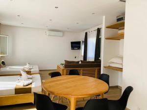 a room with a table and chairs and a bed at Odyssée Résidence in Mahajanga