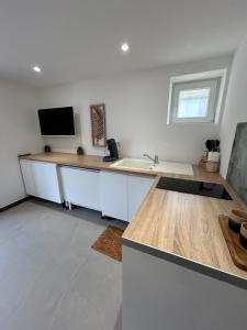 a kitchen with a counter with a sink and a tv at logement centre Bourg, parking privé in Bourg-en-Bresse