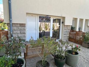 a wooden bench in front of a house with plants at logement centre Bourg, parking privé in Bourg-en-Bresse