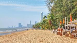a sandy beach with umbrellas and people on the beach at Navy black in Chom Bung