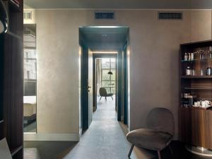 a hallway with a chair and a table in a room at ME by Meliá Milan Il Duca in Milan