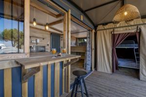 a kitchen and dining area of a tent with a bar at Camping du Lac de Cazaux in La Teste-de-Buch