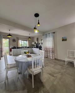 a kitchen and dining room with a table and chairs at Villa Orchidees-Albion in Albion