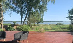 a patio with two chairs and a view of the water at Summer House With Fjord View in Kulhuse +14 photos