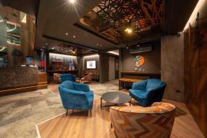 a waiting room with blue chairs and a table at CITY ASYA HOTEL in Bandırma +7 photos