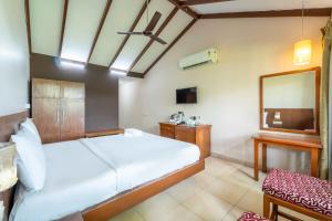 a bedroom with a large bed and a mirror at Old Goa Residency in Old Goa