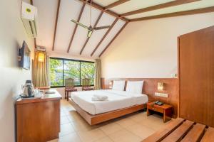 a bedroom with a bed and a table and a window at Old Goa Residency in Old Goa