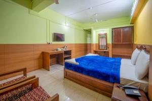 a bedroom with a large bed and a desk at Old Goa Residency in Old Goa +18 photos