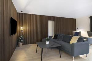 ein Wohnzimmer mit Sofa und Tisch in der Unterkunft Schönes Neu Renoviertes Sommerhaus Am Meer in Frørup