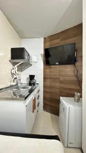 a small kitchen with a sink and a microwave at Fenomenall Kitnet in Campina Grande +3 photos