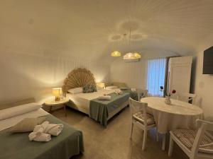 a hotel room with two beds and a table and chairs at Petra Lavea in Pompei