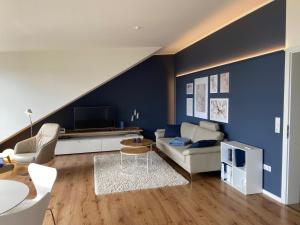 a living room with a couch and a tv at Ferienwohnung Seepanorama in Groß Wittensee