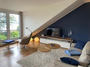 a living room with a couch and a tv at Ferienwohnung Seepanorama in Groß Wittensee