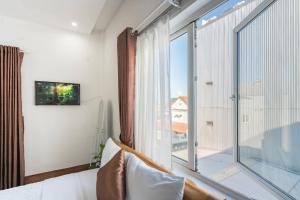 a bedroom with a large window with a view of the city at Chic Studio Homestay in Hue