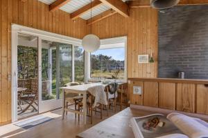 a dining room with a table and a large window at Simple Summer Living In Magical Setting in Nykøbing Sjælland +15 photos
