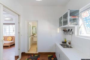 a white kitchen with a sink and a living room at Chic Studio Homestay in Hue +25 photos