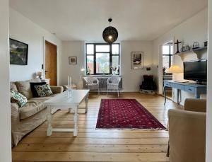a living room with a couch and a table at Charming Holiday Apartment In Central Stege in Stege