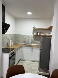 a small kitchen with white cabinets and a sink at Apartman M&M in Teslić