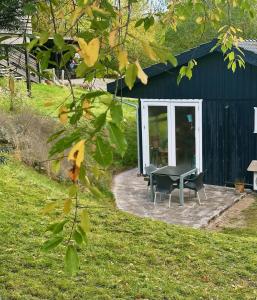 a black shed with a table and chairs in front of it at Small Oasis Near Coast And Town in Ebeltoft