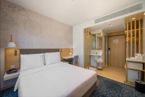 a hotel room with a white bed and a desk at Holiday Inn Express Gurugram Sector 50 by IHG in Gurgaon +59 photos