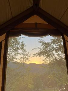 a window in a tent looking out at the mountains at Tenda Chirè in Garessio