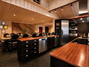 a kitchen with a stainless steel refrigerator and a table at Spacious cabin in Hemsedal, 8 bedrooms and sauna in Hemsedal