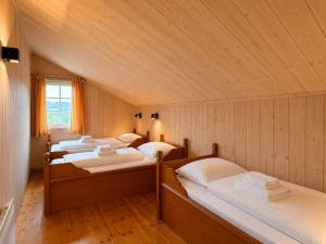 a bedroom with four beds in a room with wooden walls at Spacious cabin in Hemsedal, 8 bedrooms and sauna in Hemsedal