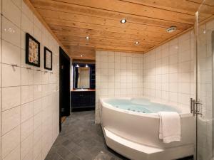 a bath tub in a bathroom with a wooden ceiling at Spacious cabin in Hemsedal, 8 bedrooms and sauna in Hemsedal +50 photos