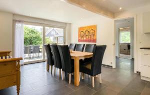 ein Esszimmer mit einem Holztisch und schwarzen Stühlen in der Unterkunft Schönes Ferienhaus Auf Bornholm Mit Meerblick in Neksø