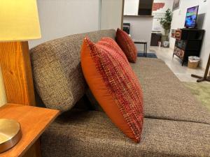 a couch with three pillows on it at Firmament Shimoshinjo in Osaka