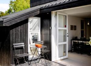 a patio with a table and chairs and a door at Exclusive Architect Designed Beach House in Karrebæksminde