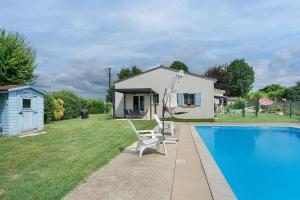 a house with a pool and two chairs next to a house at Le Cocon Taillonais avec piscine in Saint-Ciers-du-Taillon