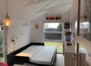 a small room with a bed and a window at Exclusive Architect Designed Beach House in Karrebæksminde