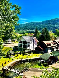 ein großes Haus mit einem Teich davor in der Unterkunft Filuma Suite - Riverside Terrace on Gacka River in Otočac
