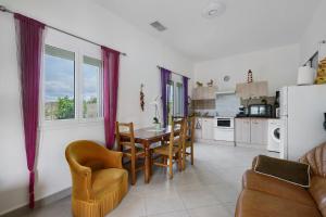 a kitchen and dining room with a table and chairs at Le Cocon Taillonais avec piscine in Saint-Ciers-du-Taillon