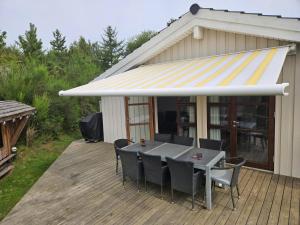 a patio with a table and chairs on a deck at Fantastic House With A Beautiful View in Ebeltoft