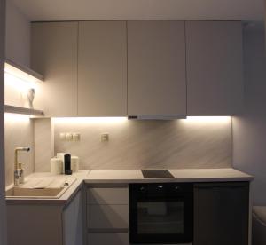 a kitchen with white cabinets and a stove top oven at Thassos Studio Kai Lani in Potamiá