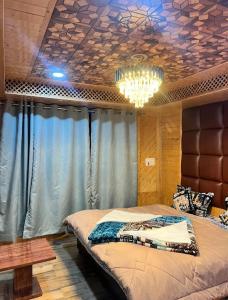 a bedroom with a large bed and a chandelier at Snow and Saffron Hotel & Restaurant in Khor