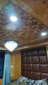 a room with a bed and a chandelier on the ceiling at Snow and Saffron Hotel & Restaurant in Khor