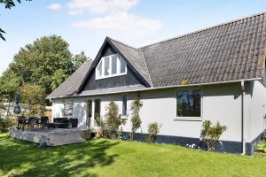 a white house with a black roof at Summerhouse With Both Island Charm And Sea View in Holbæk