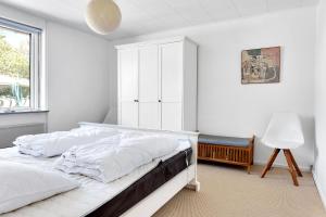 a white bedroom with a bed and a window at Summerhouse With Both Island Charm And Sea View in Holbæk