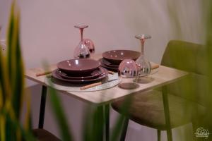 a small table with plates and glasses on it at Le Cocon Love Room & Spa in Nancy