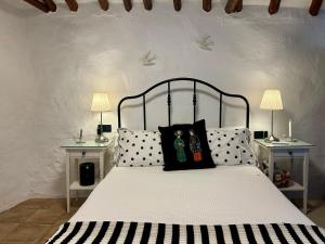 a bedroom with a bed with black and white pillows at Las casillas de la Villa: TANGO in Montefrío