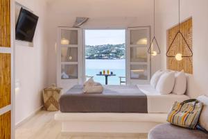 a bedroom with a bed with a view of the ocean at Alidian bay Suites Leros in Alinda