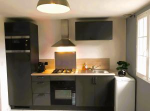 a kitchen with a sink and a stove top oven at Gîte de Rosemont in Saint-Pol-sur-Ternoise