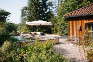 a pool with an umbrella next to a house at NaturQuartier am Stadtrand von Nürnberg in Stein