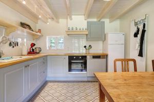 a kitchen with white appliances and a wooden table at Gîte Le Cèdre, sans vis-à-vis in Limeyrat