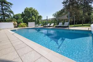 a swimming pool with blue water in a yard at Gîte Le Cèdre, sans vis-à-vis in Limeyrat