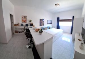 ein weißes Schlafzimmer mit einem Bett und einem weißen Schreibtisch in der Unterkunft 56, Windchimes in Pembroke
